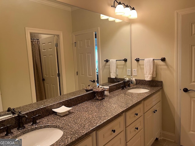 bathroom featuring double vanity, ornamental molding, tile patterned flooring, and a sink