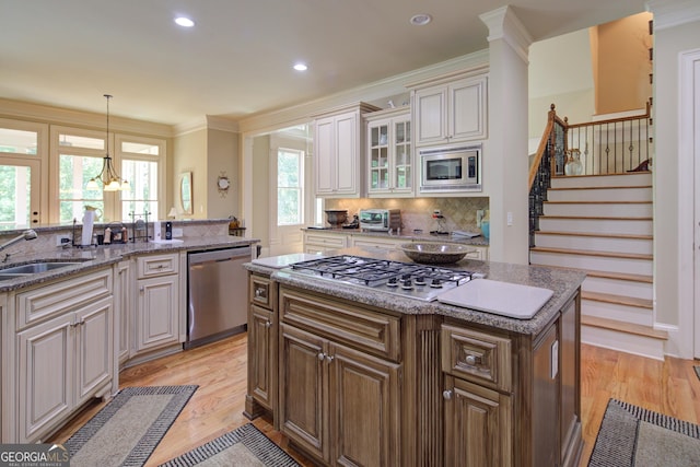 8440 Woodland Brooke Trl, Cumming, GA 30028 - kitchen with appliances with stainless steel finishes, a sink, crown molding, backsplash, and a center island