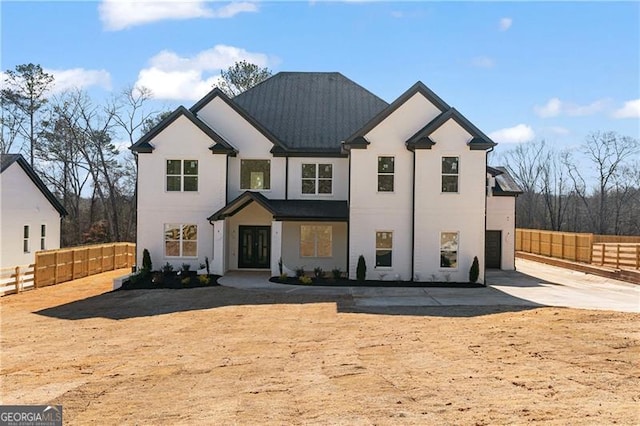 modern inspired farmhouse featuring fence private yard, driveway, and an attached garage