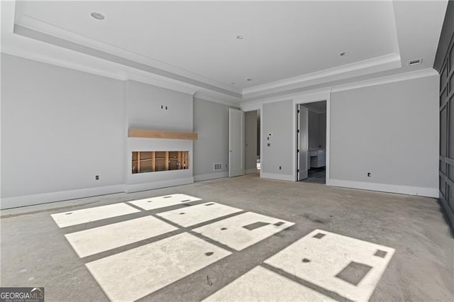 unfurnished living room featuring a fireplace, a tray ceiling, and ornamental molding