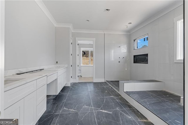 bathroom with marble finish floor, ornamental molding, and plenty of natural light