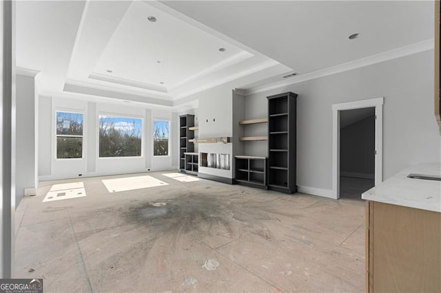 unfurnished living room with a fireplace, baseboards, a raised ceiling, and crown molding