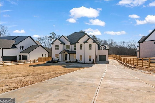 view of front of property featuring driveway, an attached garage, fence, and a residential view