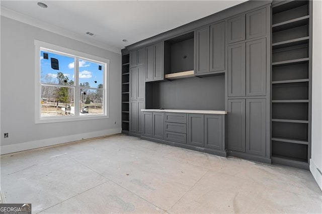 unfurnished living room featuring built in features, crown molding, and baseboards