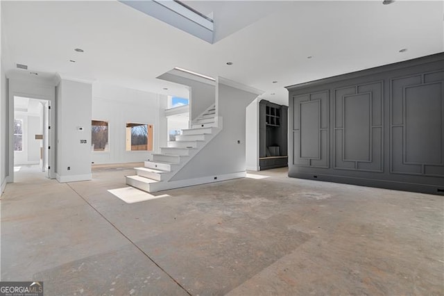 unfurnished living room featuring visible vents, concrete floors, baseboards, and stairs