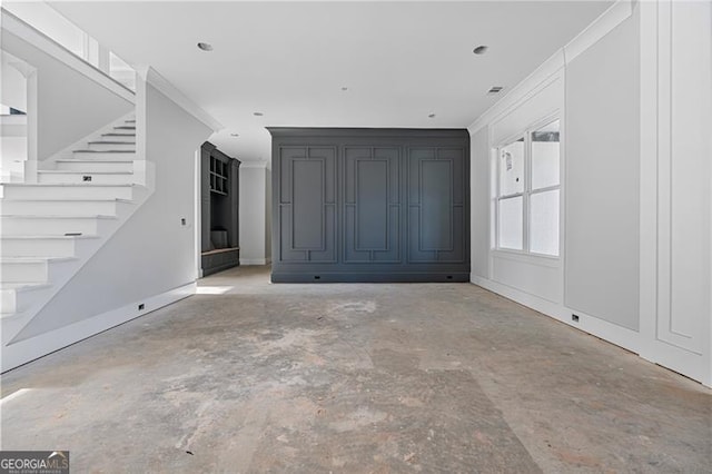 unfurnished living room featuring crown molding, concrete floors, stairway, and baseboards