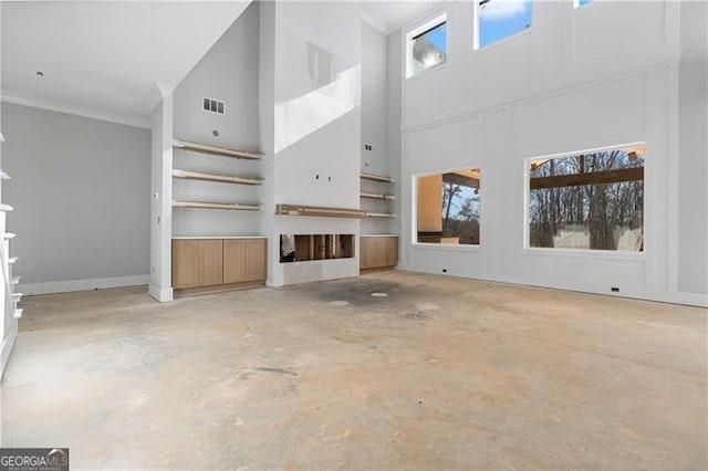 unfurnished living room featuring a wealth of natural light, visible vents, and unfinished concrete flooring