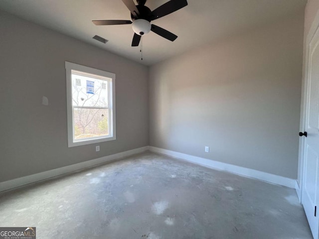 spare room with unfinished concrete floors, baseboards, and a ceiling fan