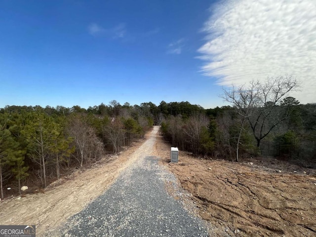 view of road with a wooded view