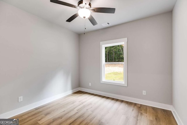 unfurnished room featuring baseboards, visible vents, and light wood-style floors