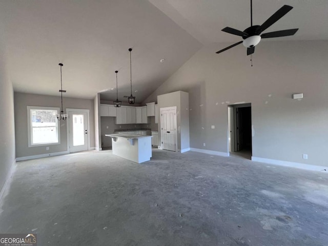 kitchen featuring high vaulted ceiling, a kitchen island, white cabinets, open floor plan, and pendant lighting