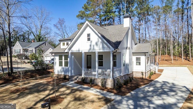 view of front of property featuring covered porch, a shingled roof, and a chimney