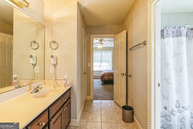 ensuite bathroom featuring wallpapered walls, baseboards, connected bathroom, tile patterned flooring, and vanity