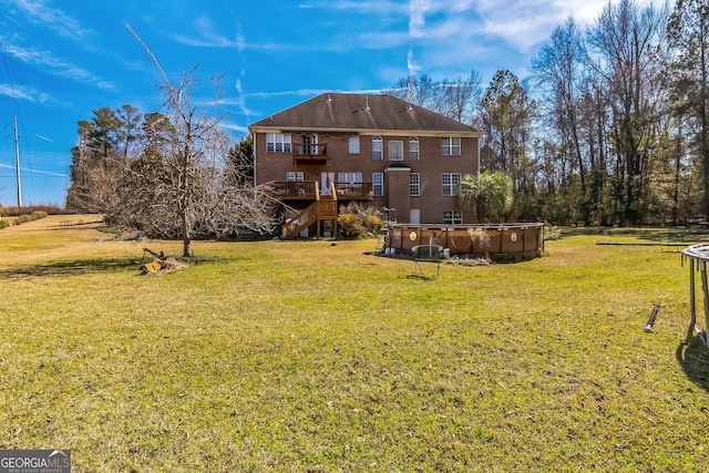 view of yard with a deck, stairway, and an outdoor pool