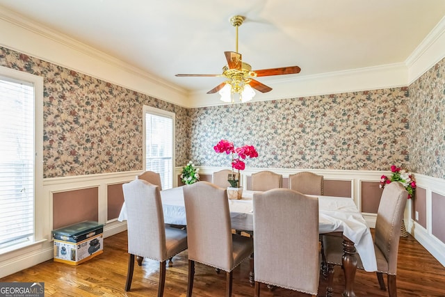 dining space featuring wainscoting, wood finished floors, a ceiling fan, and wallpapered walls