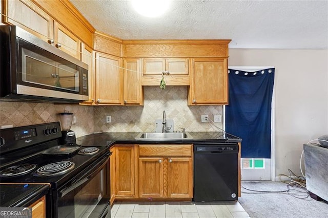 kitchen with dark countertops, a sink, a textured ceiling, black appliances, and backsplash