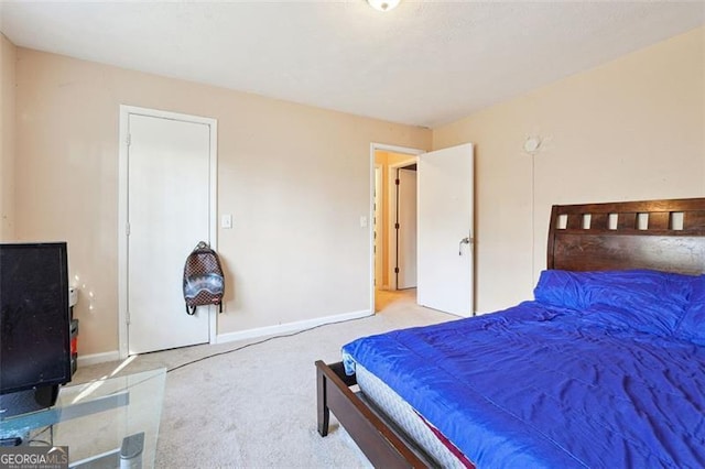 bedroom featuring light carpet and baseboards