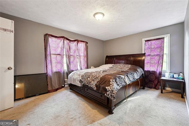 bedroom featuring a textured ceiling and light colored carpet