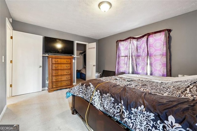 bedroom featuring a textured ceiling, a spacious closet, and a closet