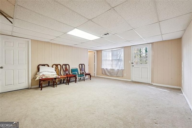 sitting room with carpet floors, visible vents, a drop ceiling, and baseboards