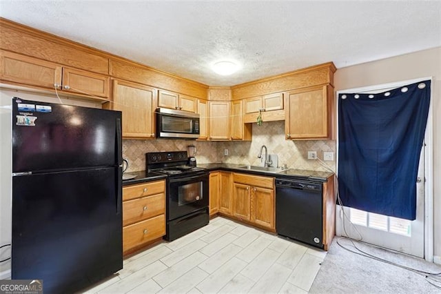 kitchen with tasteful backsplash, dark countertops, brown cabinets, black appliances, and a sink