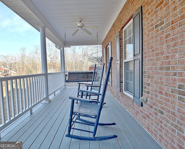 wooden terrace with a porch and ceiling fan