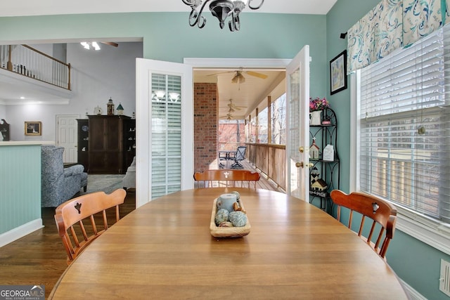 dining room with ceiling fan with notable chandelier, baseboards, and wood finished floors