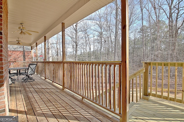 wooden terrace featuring outdoor dining area and a ceiling fan