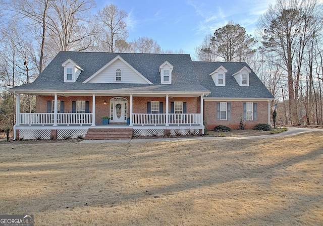 view of front facade featuring a front lawn, a porch, and brick siding