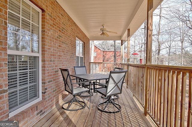 snow covered deck with ceiling fan and outdoor dining space