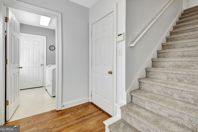 staircase with independent washer and dryer and baseboards