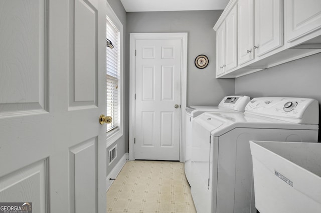 laundry area with cabinet space, visible vents, light floors, washing machine and dryer, and a sink