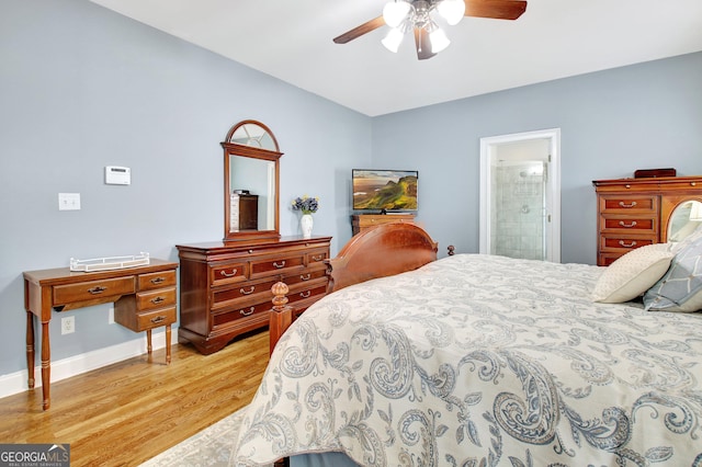 bedroom featuring light wood finished floors, baseboards, connected bathroom, a ceiling fan, and vaulted ceiling