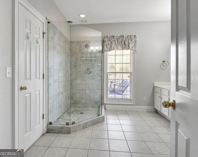 bathroom with baseboards, a shower stall, vanity, and tile patterned floors