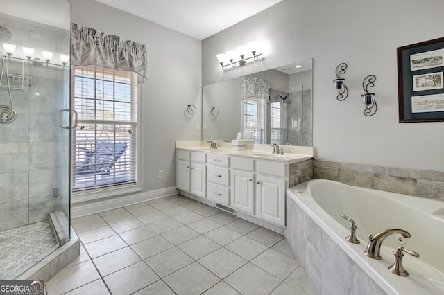 bathroom featuring a jetted tub, double vanity, a sink, and tile patterned floors