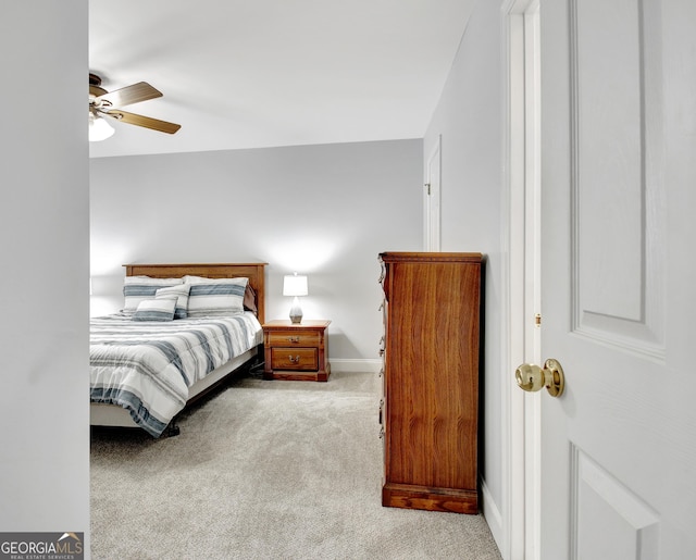 bedroom with a ceiling fan, light carpet, and baseboards