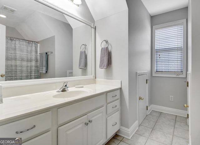 bathroom featuring baseboards, visible vents, lofted ceiling, tile patterned floors, and vanity