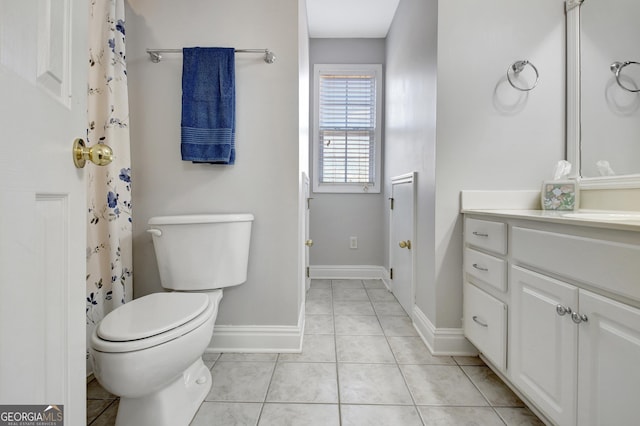 bathroom with baseboards, vanity, toilet, and tile patterned floors