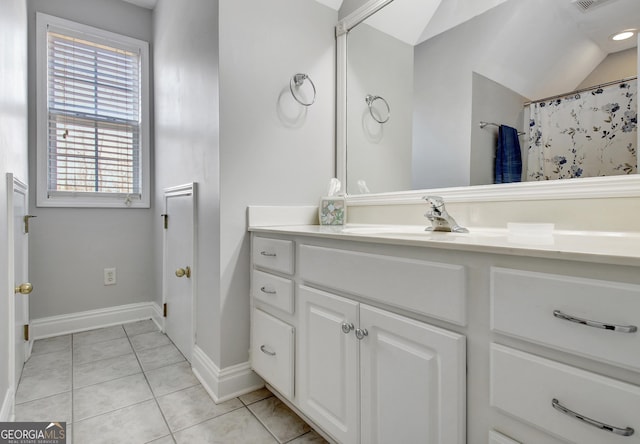 full bath featuring lofted ceiling, visible vents, vanity, baseboards, and tile patterned floors