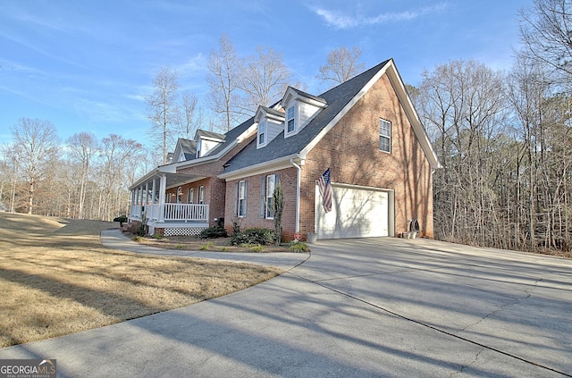 view of property exterior featuring driveway, a shingled roof, an attached garage, covered porch, and brick siding