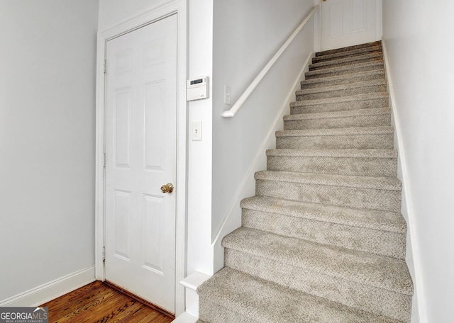 stairs with wood finished floors and baseboards