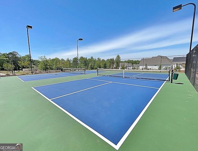 view of tennis court featuring fence