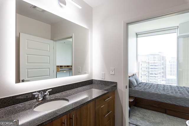 bathroom with a view of city, ensuite bath, vanity, and visible vents