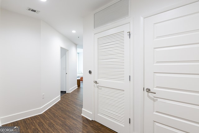 hall with visible vents, baseboards, dark wood-type flooring, and recessed lighting