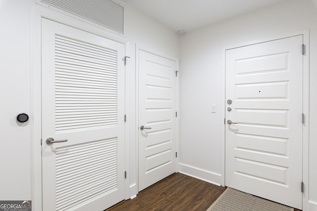 entryway with dark wood finished floors and baseboards