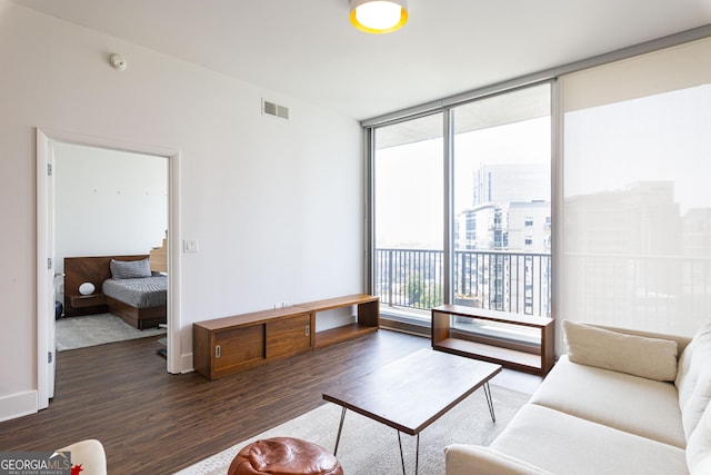 living area featuring a view of city, dark wood finished floors, visible vents, expansive windows, and baseboards