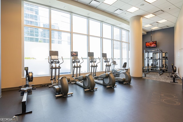 workout area with plenty of natural light, a high ceiling, visible vents, and a drop ceiling