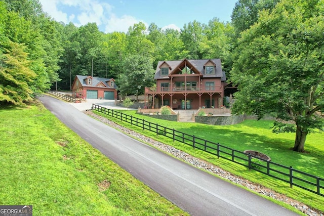 view of front of property featuring a garage, fence, and a front lawn