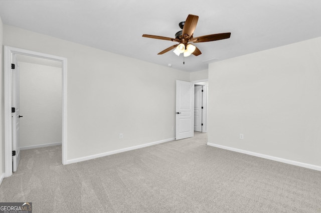 carpeted empty room with ceiling fan and baseboards