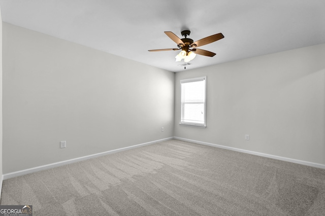 carpeted empty room with a ceiling fan and baseboards